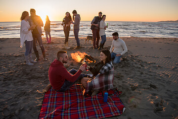 Image showing Couple enjoying with friends at sunset on the beach