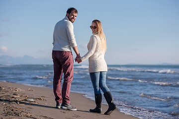 Image showing Loving young couple on a beach at autumn sunny day