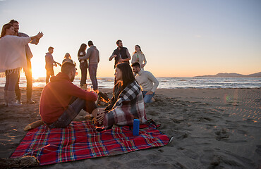 Image showing Couple enjoying with friends at sunset on the beach