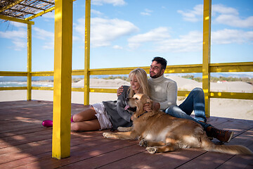 Image showing Couple with dog enjoying time on beach