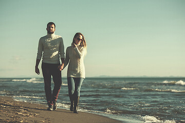 Image showing Loving young couple on a beach at autumn sunny day