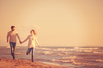 Image showing Loving young couple on a beach at autumn sunny day