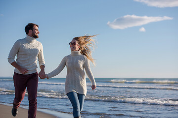 Image showing Loving young couple on a beach at autumn sunny day