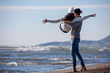 Image showing Loving young couple on a beach at autumn sunny day