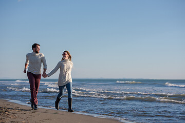 Image showing Loving young couple on a beach at autumn sunny day