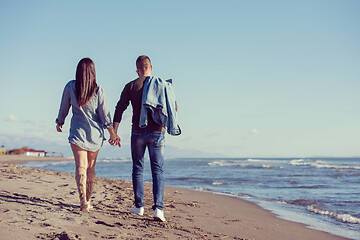 Image showing Loving young couple on a beach at autumn sunny day