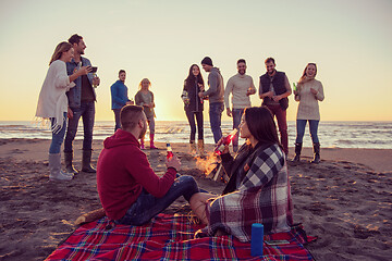 Image showing Couple enjoying with friends at sunset on the beach