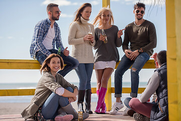 Image showing Group of friends having fun on autumn day at beach