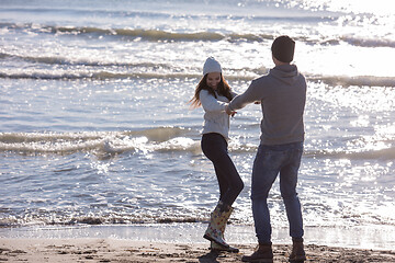 Image showing Loving young couple on a beach at autumn sunny day