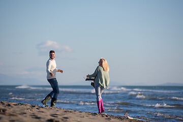 Image showing Loving young couple on a beach at autumn sunny day