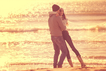 Image showing Loving young couple on a beach at autumn sunny day