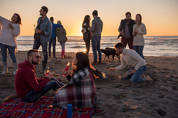 Image showing Couple enjoying with friends at sunset on the beach