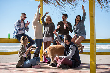 Image showing Group of friends having fun on autumn day at beach