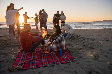 Image showing Couple enjoying with friends at sunset on the beach