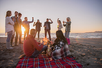 Image showing Couple enjoying with friends at sunset on the beach