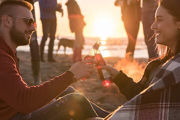 Image showing Couple enjoying with friends at sunset on the beach