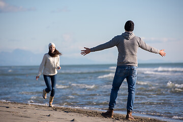 Image showing Loving young couple on a beach at autumn sunny day