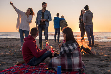 Image showing Couple enjoying with friends at sunset on the beach