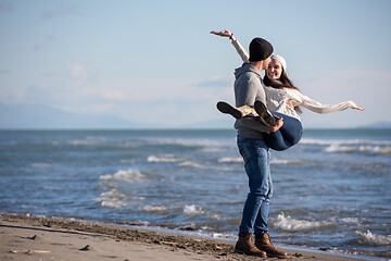 Image showing Loving young couple on a beach at autumn sunny day