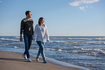 Image showing Loving young couple on a beach at autumn sunny day