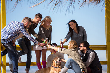 Image showing Group of friends having fun on autumn day at beach