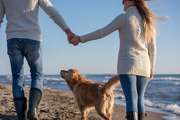 Image showing couple with dog having fun on beach on autmun day