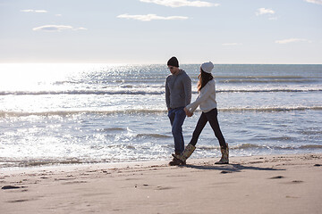 Image showing Loving young couple on a beach at autumn sunny day