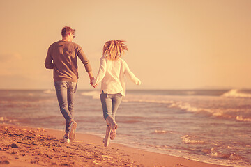 Image showing Loving young couple on a beach at autumn sunny day