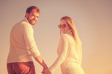 Image showing Loving young couple on a beach at autumn sunny day