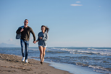 Image showing Loving young couple on a beach at autumn sunny day