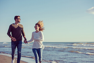 Image showing Loving young couple on a beach at autumn sunny day