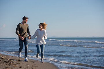 Image showing Loving young couple on a beach at autumn sunny day