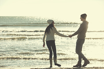 Image showing Loving young couple on a beach at autumn sunny day