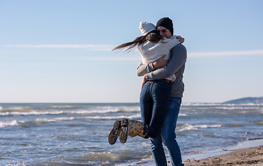 Image showing Loving young couple on a beach at autumn sunny day