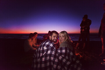 Image showing Couple enjoying with friends at sunset on the beach