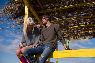 Image showing young couple drinking beer together at the beach