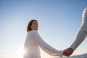 Image showing Loving young couple on a beach at autumn sunny day