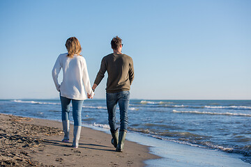 Image showing Loving young couple on a beach at autumn sunny day