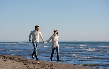 Image showing Loving young couple on a beach at autumn sunny day