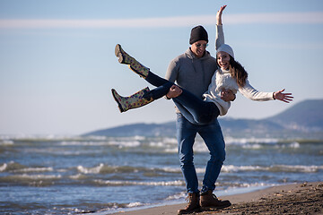 Image showing Loving young couple on a beach at autumn sunny day