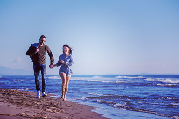 Image showing Loving young couple on a beach at autumn sunny day