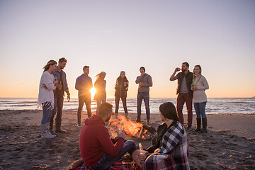 Image showing Couple enjoying with friends at sunset on the beach