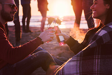 Image showing Couple enjoying with friends at sunset on the beach