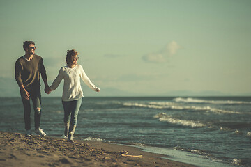 Image showing Loving young couple on a beach at autumn sunny day