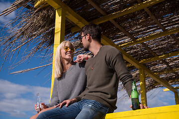 Image showing young couple drinking beer together at the beach