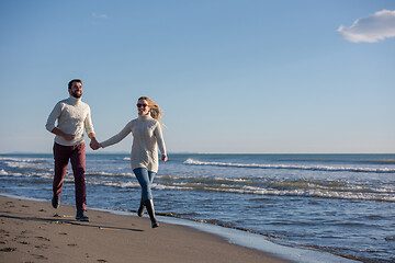 Image showing Loving young couple on a beach at autumn sunny day