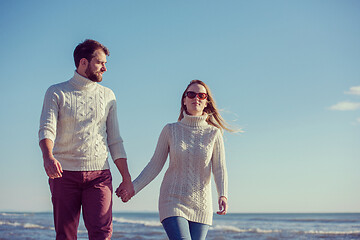 Image showing Loving young couple on a beach at autumn sunny day