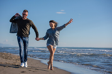 Image showing Loving young couple on a beach at autumn sunny day