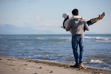 Image showing Loving young couple on a beach at autumn sunny day