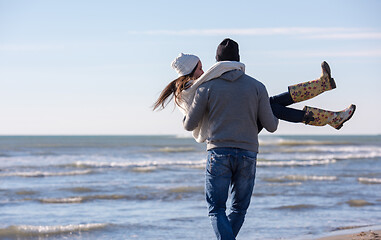 Image showing Loving young couple on a beach at autumn sunny day